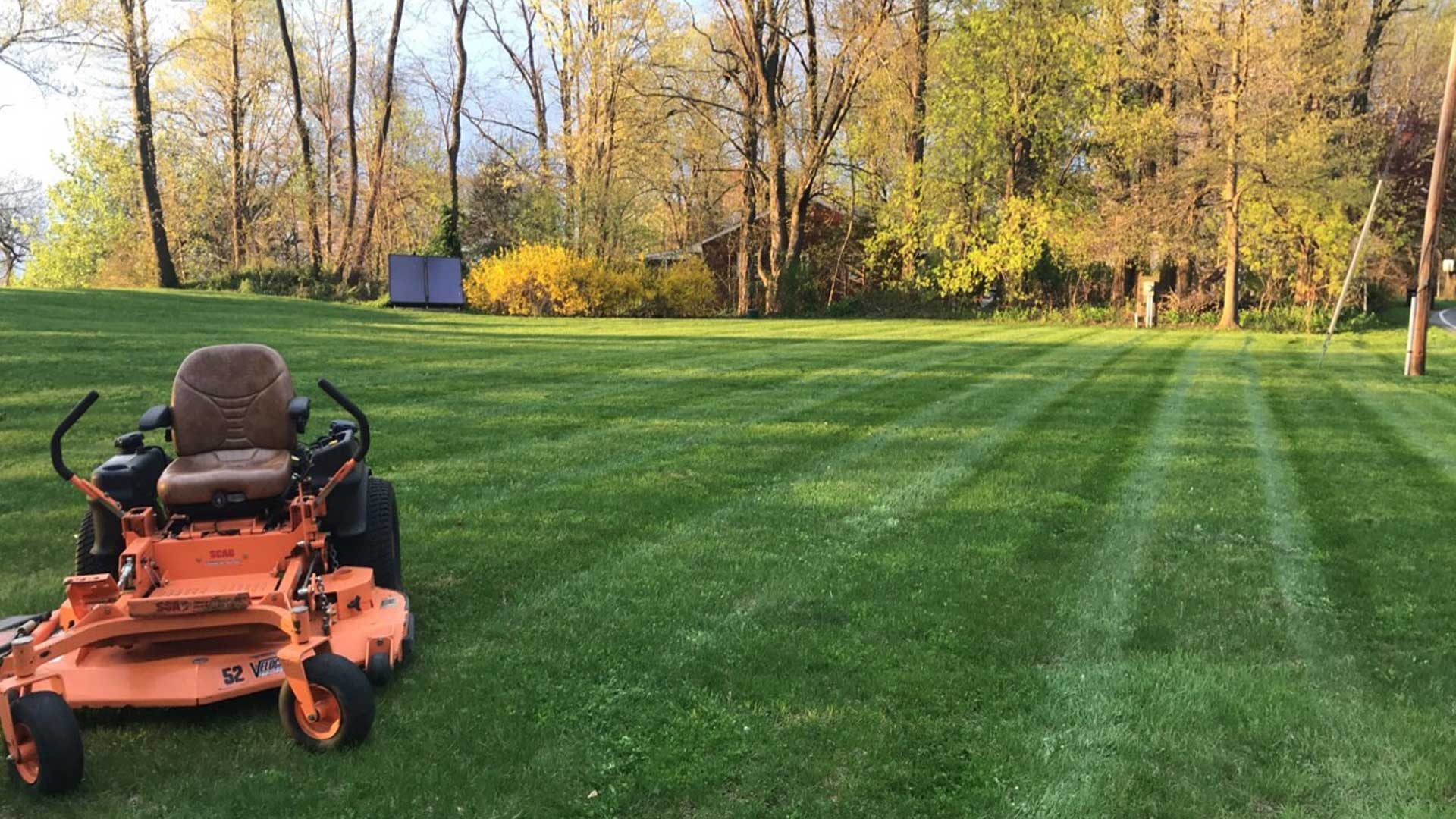 Our lawn mower parked on a lawn that was recently mowed by our team.